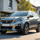 Peugeot 3008 gris brillant devant maison moderne ensoleillee